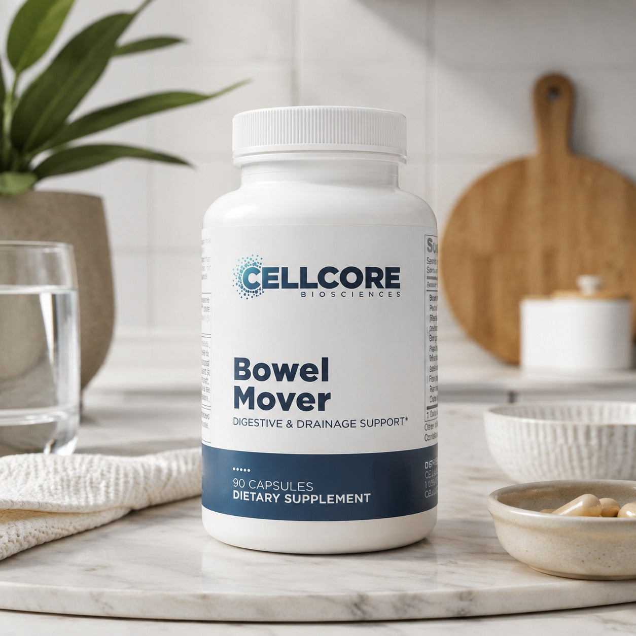 A white bottle of Bowel Mover dietary supplement capsules, placed on a marble countertop in a bright kitchen setting with a glass of water, a wooden cutting board, and a small bowl of capsules nearby.